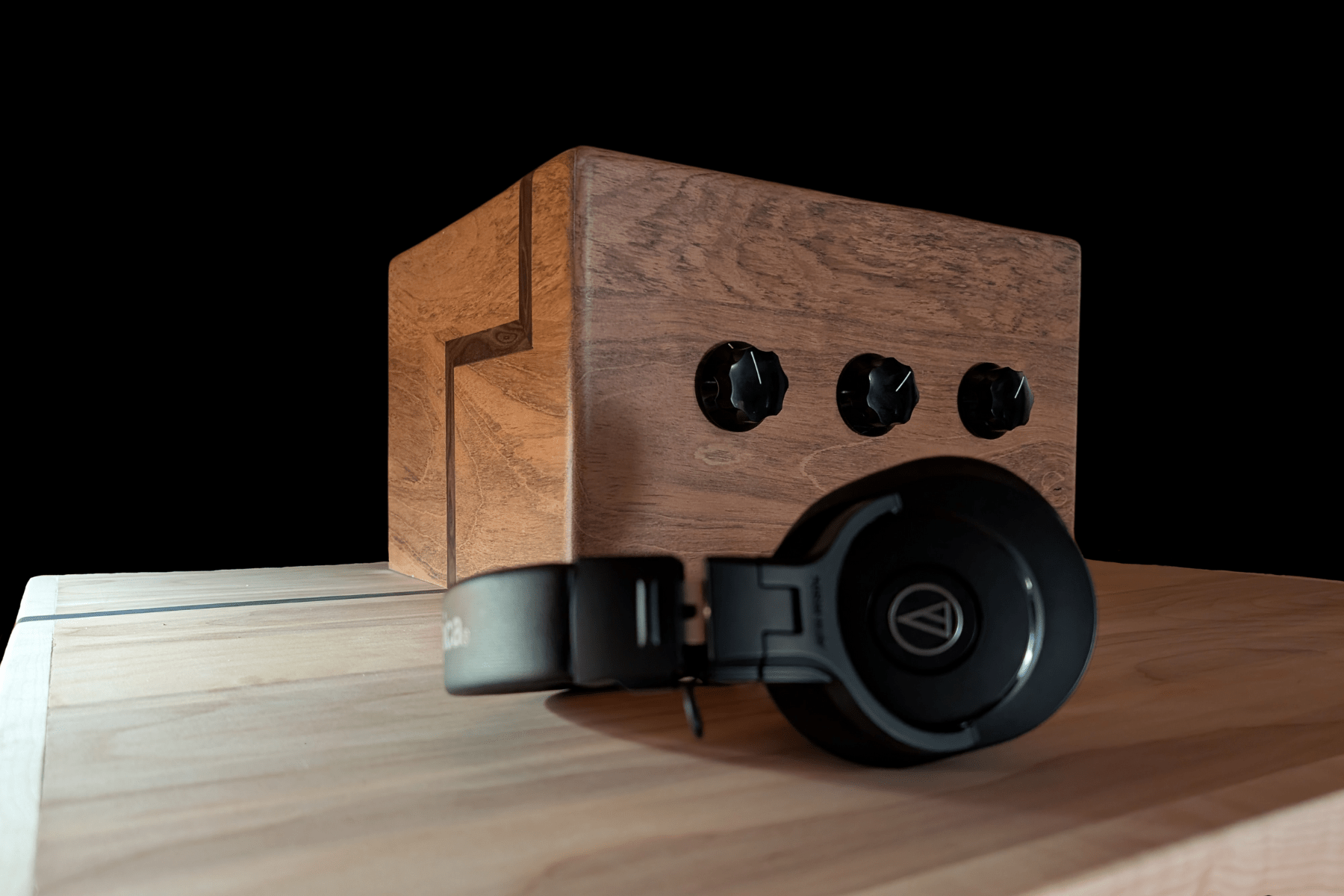 Wooden box full of electrical things that play music through headphones.