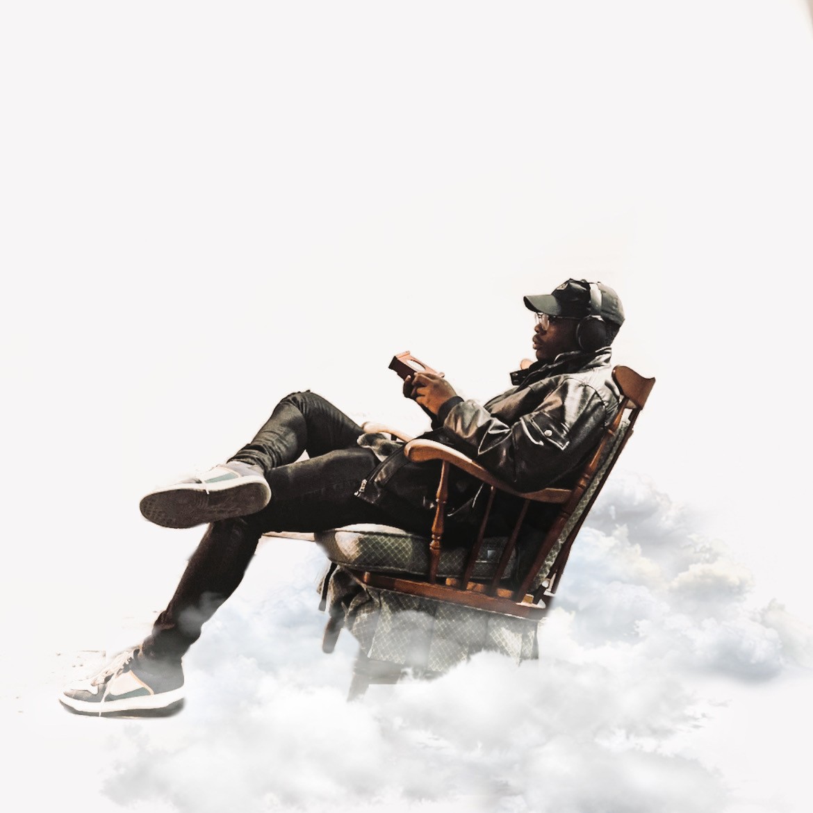 A man sits on a chair, in a white clouded background.